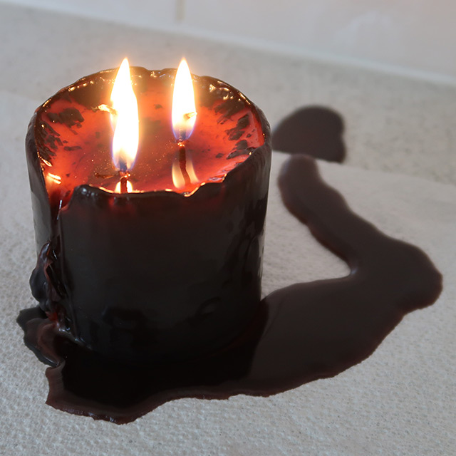 The pillar candle, lit and melting