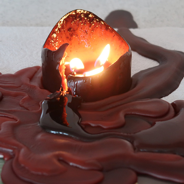 The pillar candle, lit and very melted