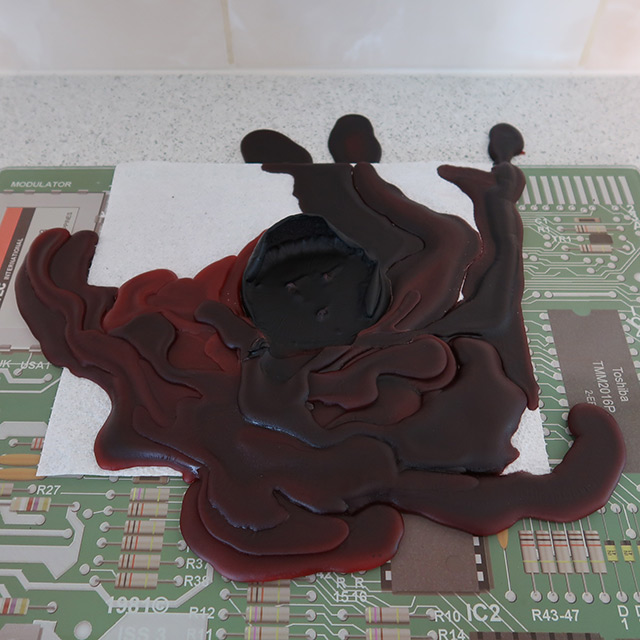 The pillar candle, fully melted and extinguished